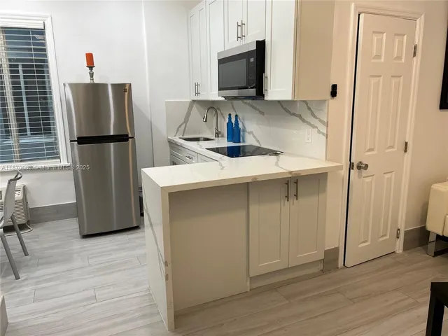 a kitchen with white cabinets and a sink