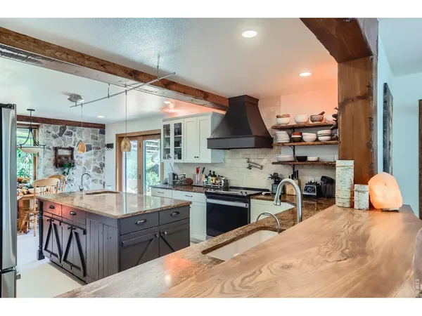 a kitchen with stainless steel appliances kitchen island granite countertop a sink and cabinets