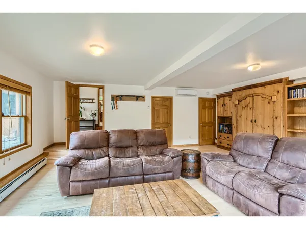 a living room with furniture a flat screen tv and a large window