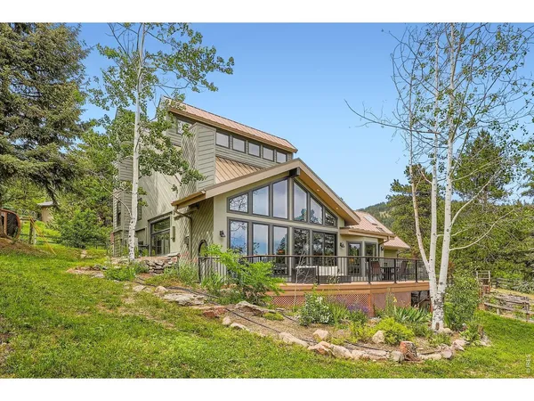 a view of a house with a yard and deck
