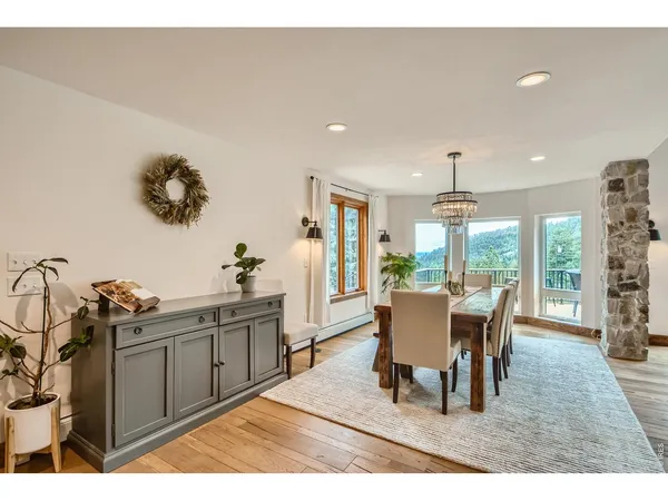a dining room with furniture a rug and a large window