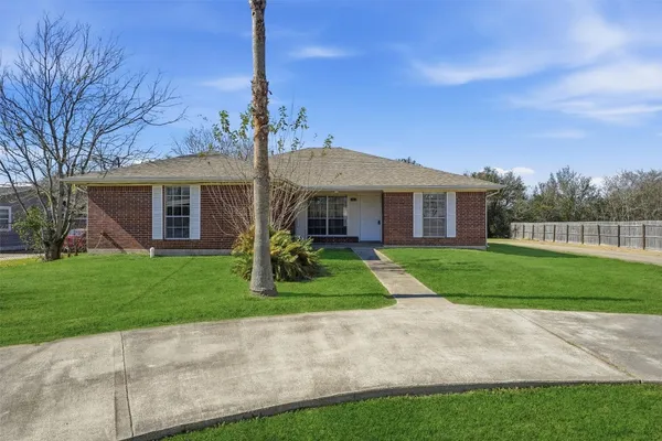 a front view of a house with a yard and trees