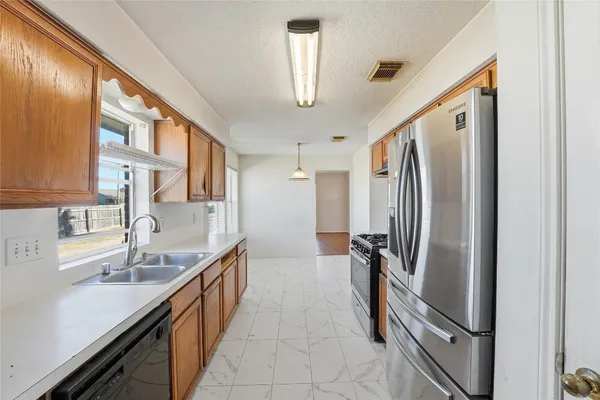 a kitchen with stainless steel appliances granite countertop a refrigerator and a sink
