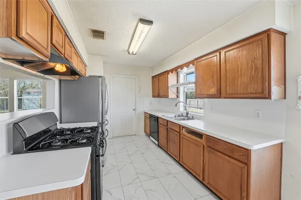 a kitchen with stainless steel appliances a sink stove and cabinets