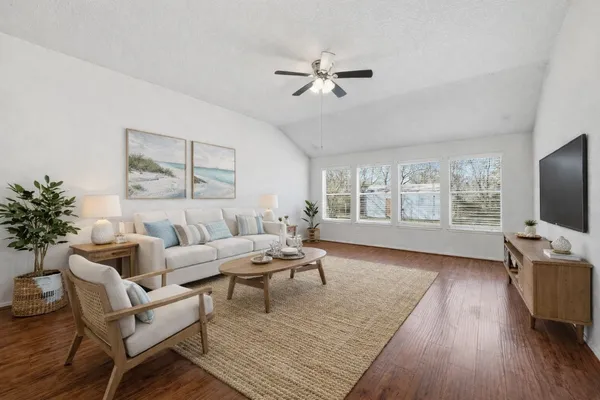 a living room with furniture wooden floor and a flat screen tv