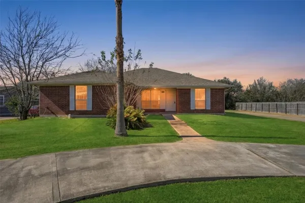 a front view of a house with a yard and trees