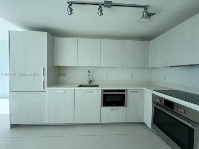 a kitchen with cabinets appliances and a sink