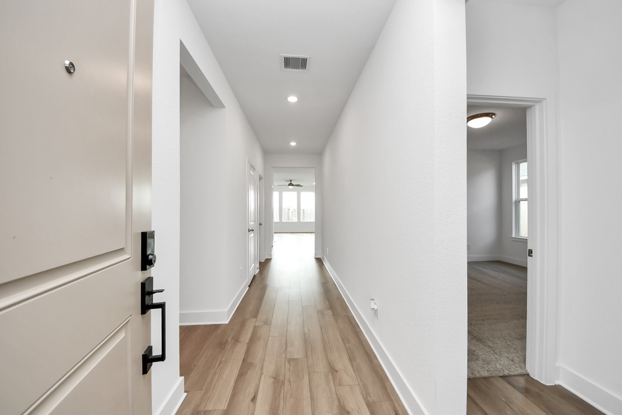a view of a hallway with wooden floor and staircase