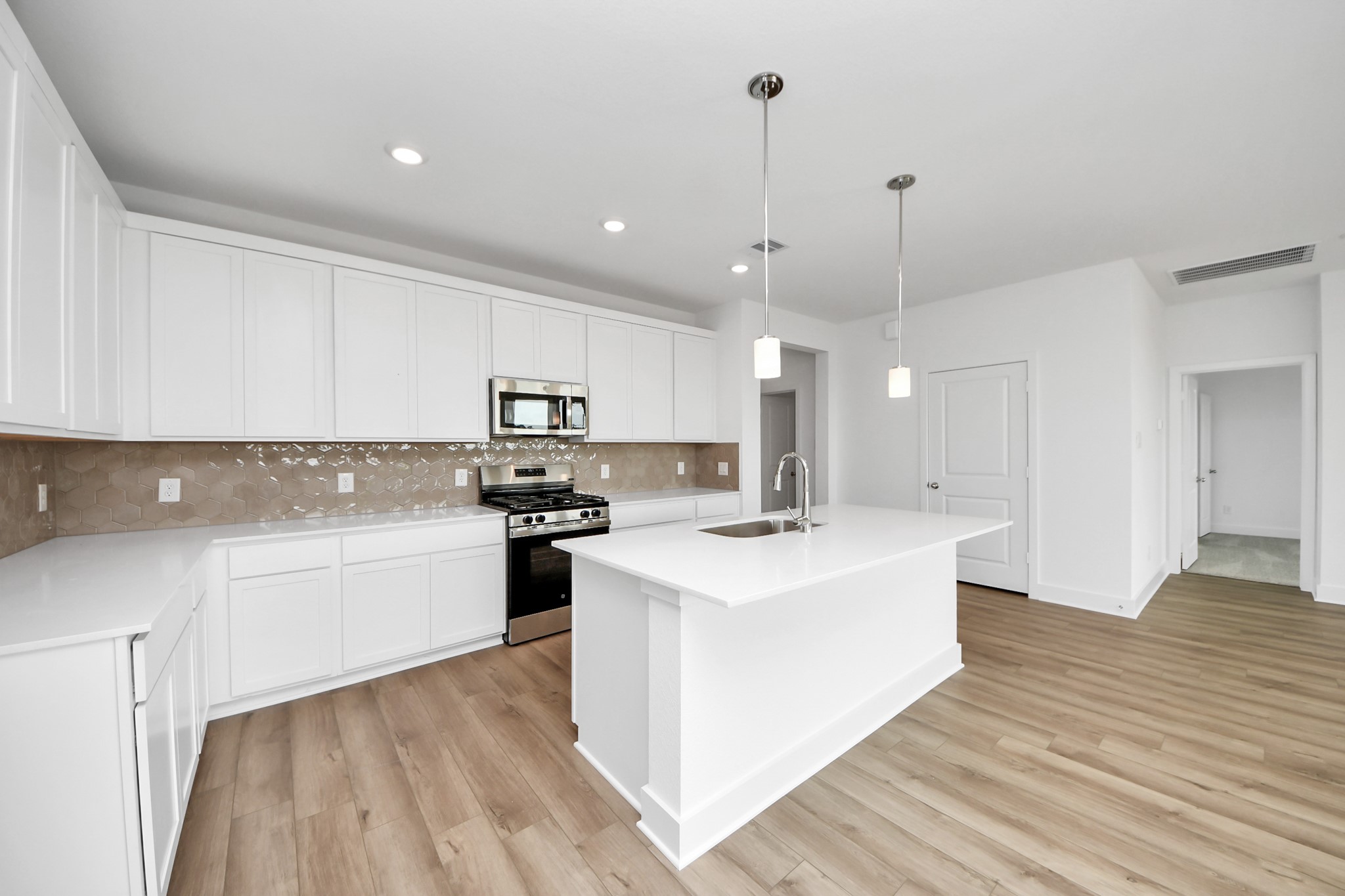 14471 Trumpet Lane Splendora, TX 77372 - Photo 5 of 33 a kitchen with stainless steel appliances granite countertop a sink a stove a refrigerator and white cabinets with wooden floor