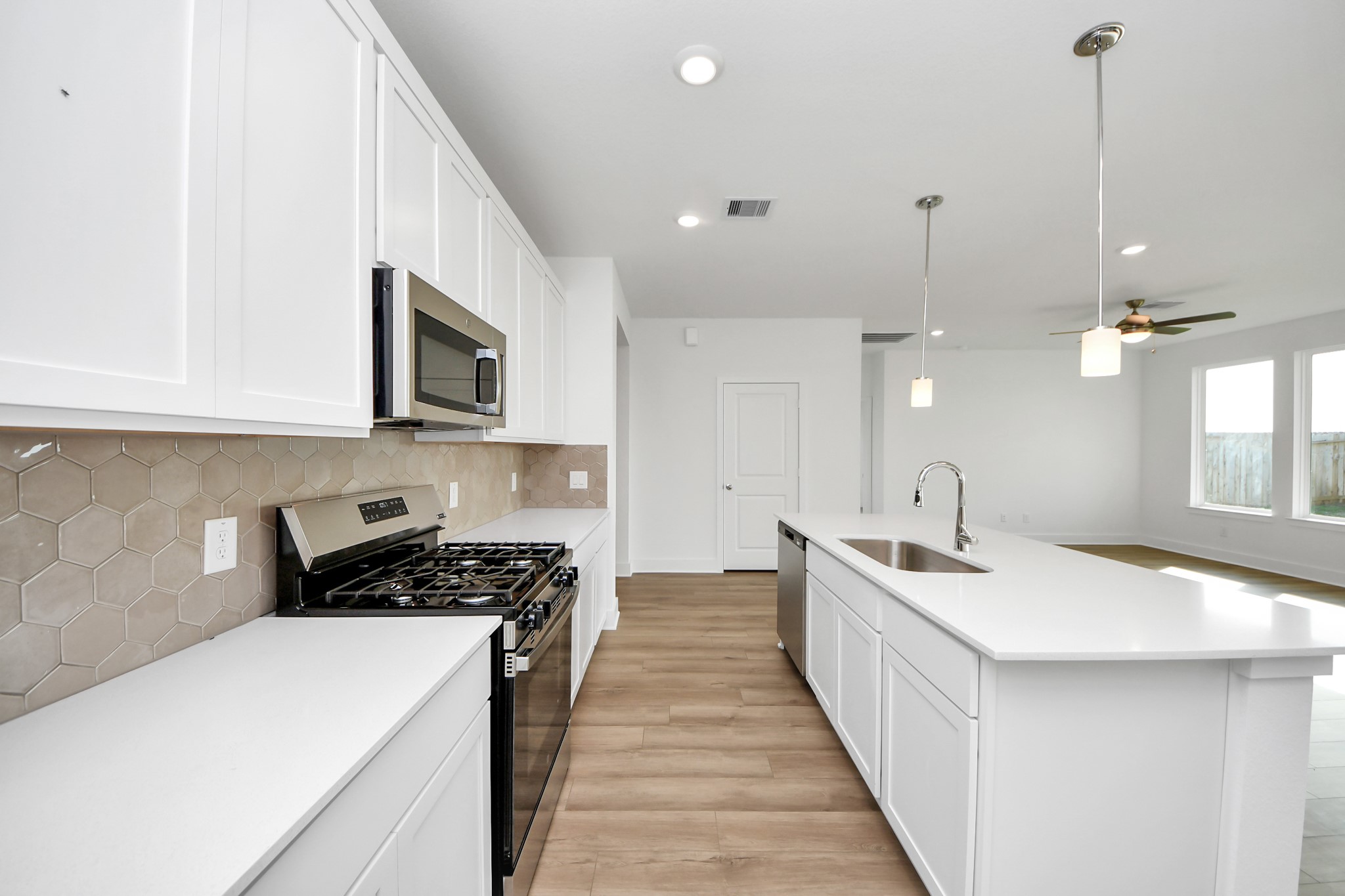 14471 Trumpet Lane Splendora, TX 77372 - Photo 6 of 33 a kitchen with stainless steel appliances a sink a stove top oven a counter space and cabinets
