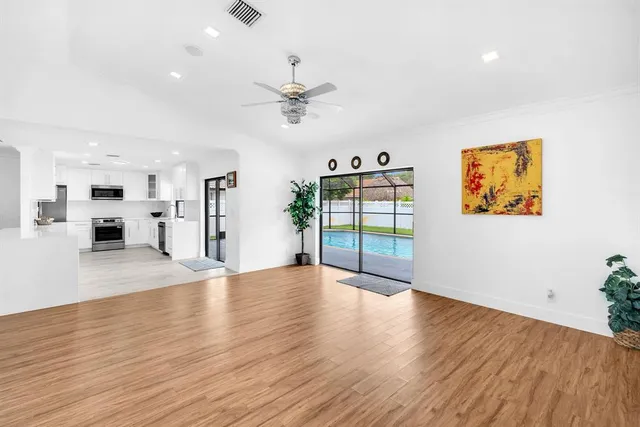 a large white kitchen with a large window and stainless steel appliances