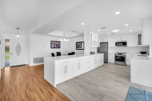 a kitchen with granite countertop white cabinets and white appliances