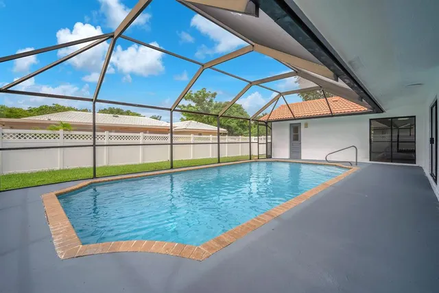 an aerial view of a house with swimming pool and garden