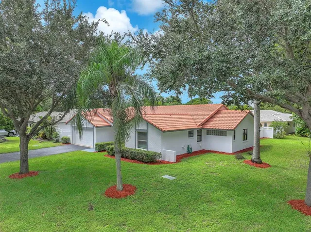 an aerial view of residential houses with outdoor space and trees