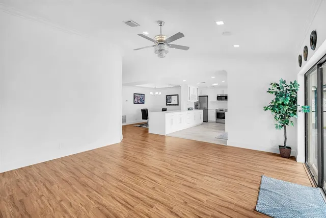 a view of a living room and kitchen with wooden floor