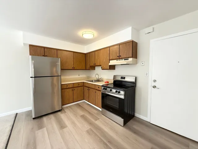 a kitchen with a refrigerator stove and wooden cabinets