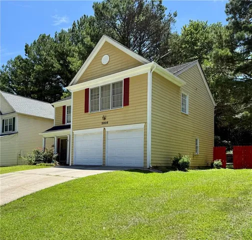 a front view of a house with a yard and garage