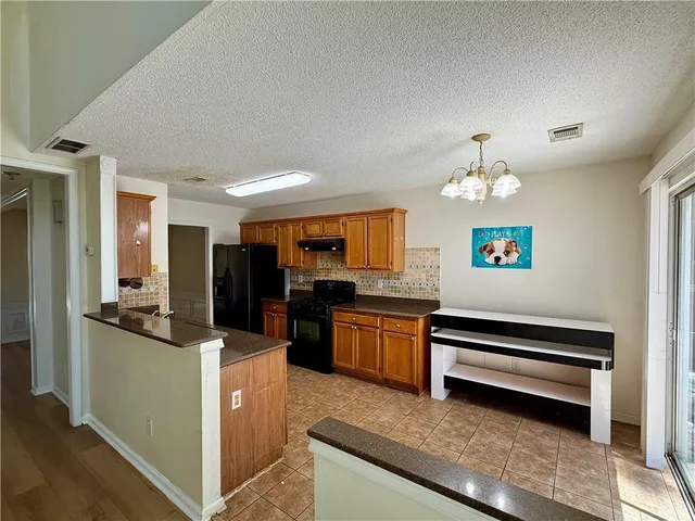 a kitchen with stainless steel appliances granite countertop a refrigerator and a stove top oven