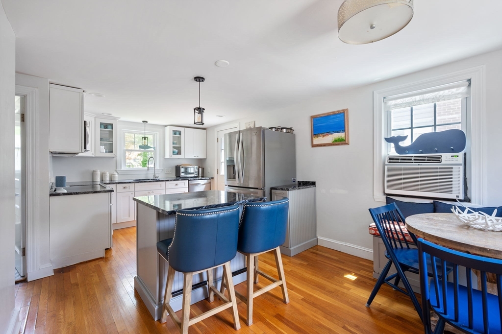 40 Lyman Road Milton, MA 02186 - Photo 2 of 28 a kitchen with granite countertop a dining table chairs and a refrigerator
