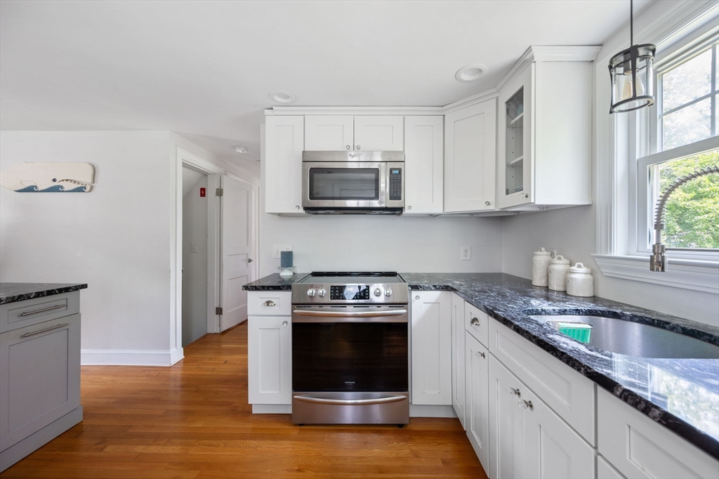 40 Lyman Road Milton, MA 02186 - Photo 4 of 28 a kitchen with granite countertop a stove a microwave a sink and cabinets
