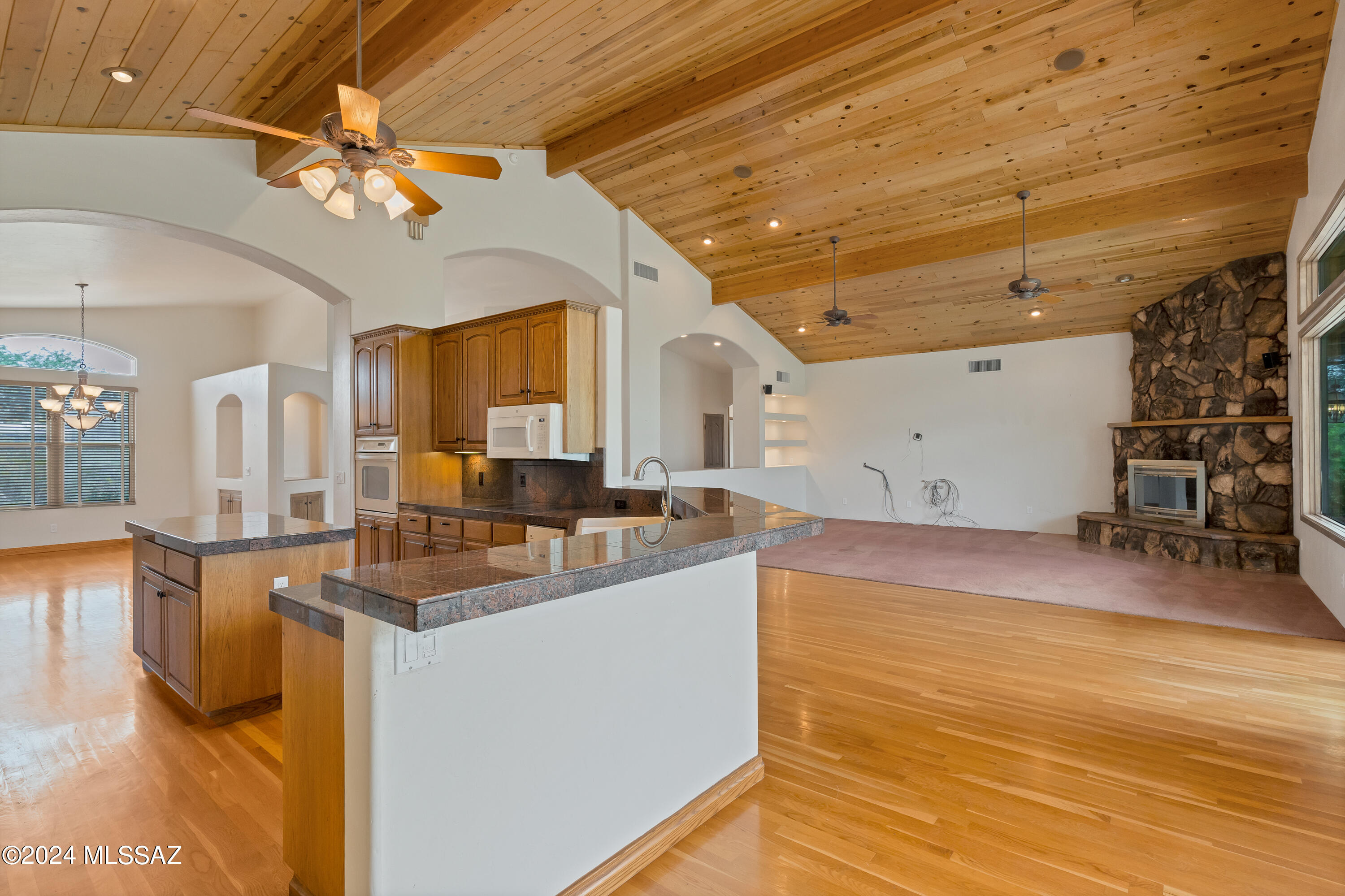 4001 North Harrison Road Tucson, AZ 85749 - Photo 12 of 50 a view of a kitchen with kitchen island a sink wooden floor and a glass top table