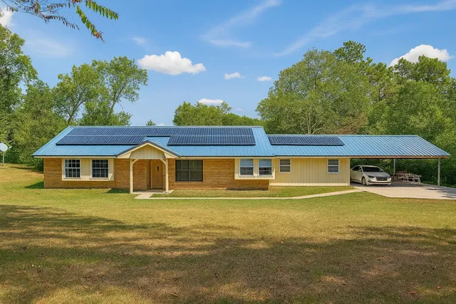 a front view of a house with yard and swimming pool