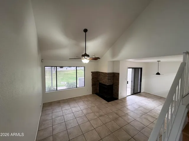 a view of empty room with a fireplace and windows