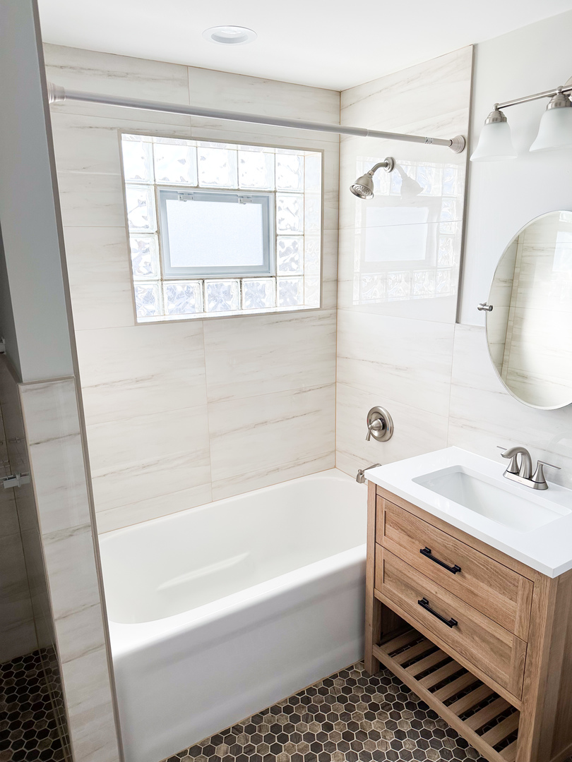 4943 West 63rd Street, Unit 201 Chicago, IL 60638 - Photo 5 of 5 a bathroom with a bathtub a sink and a mirror