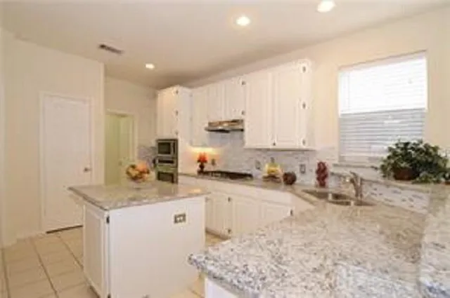 a kitchen with a sink stove and cabinets