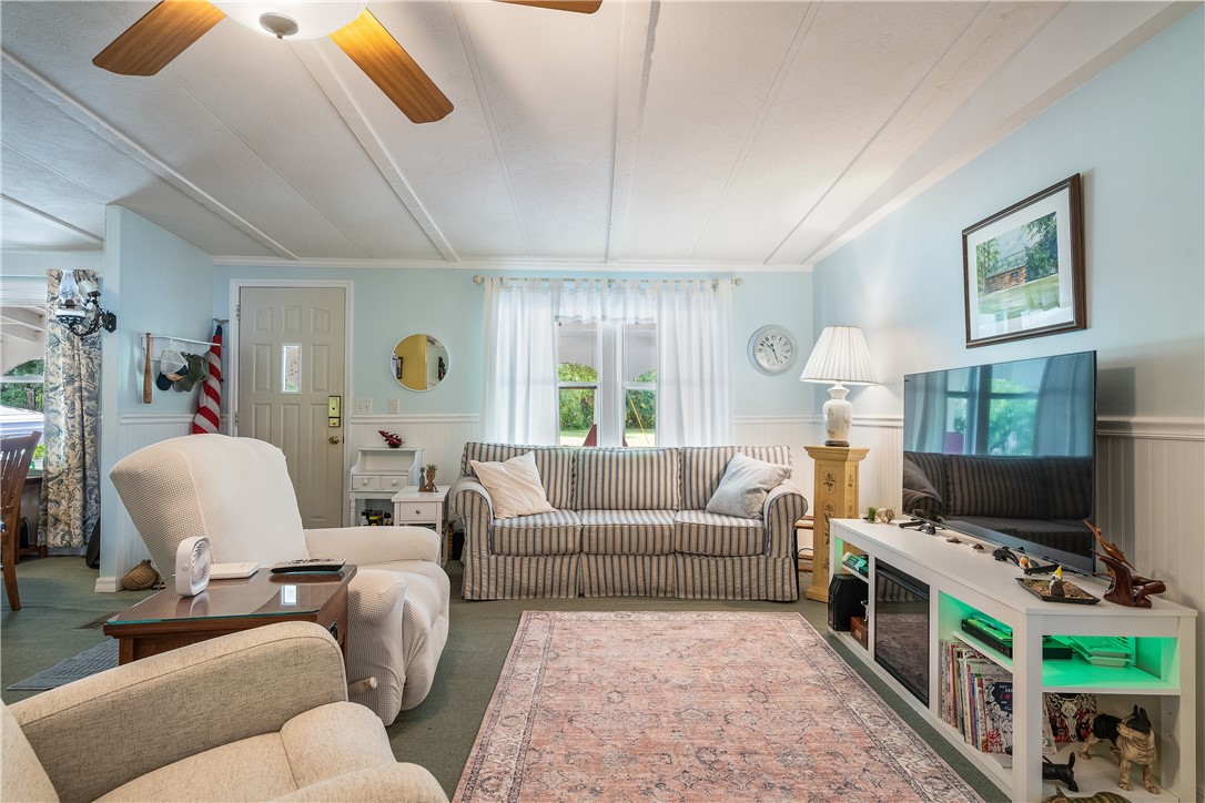 5660 Cypress Drive Yeehaw Junction, FL 34972 - Photo 16 of 36 a living room with furniture and a flat screen tv