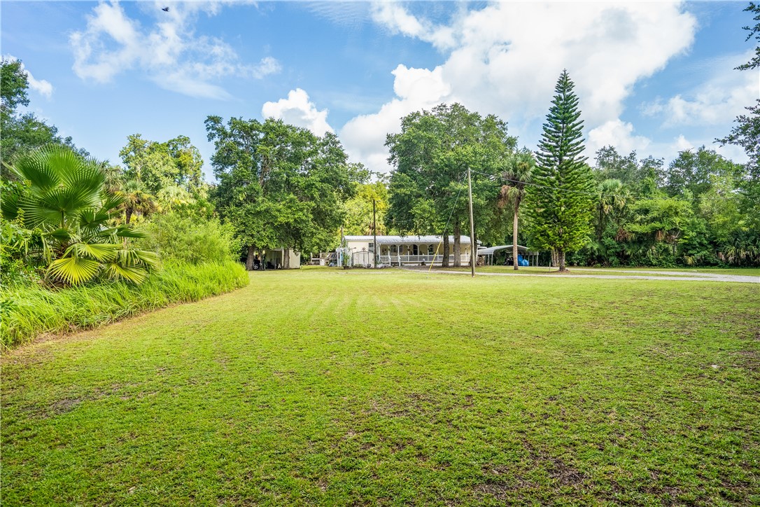 5660 Cypress Drive Yeehaw Junction, FL 34972 - Photo 31 of 36 a view of outdoor space with garden and trees
