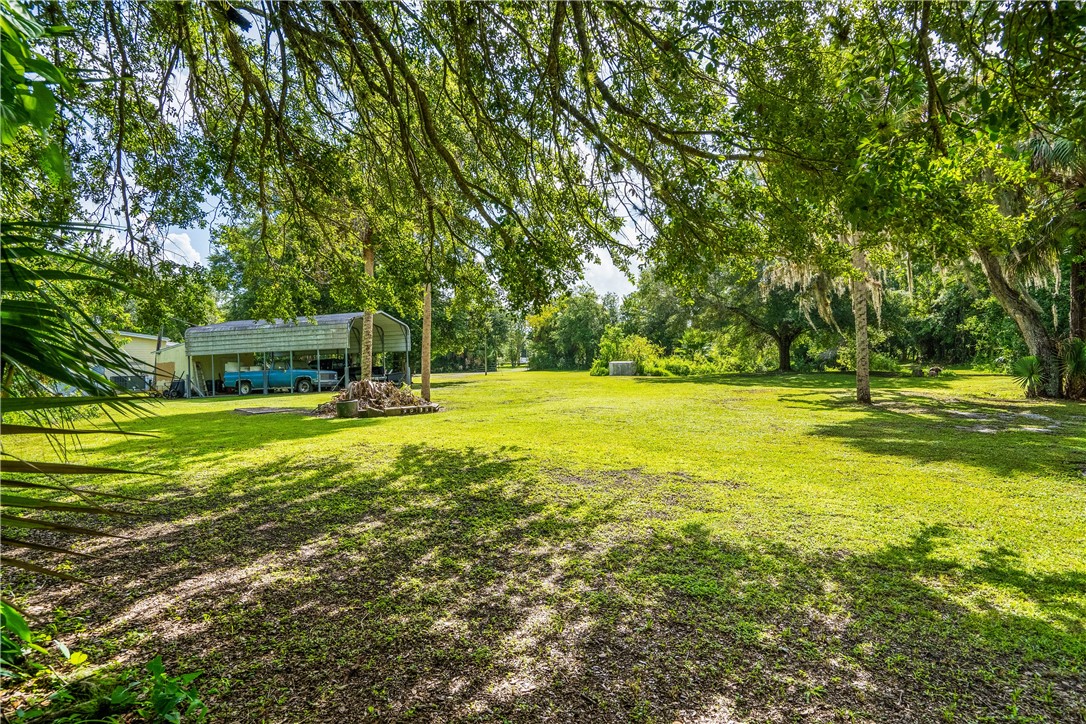5660 Cypress Drive Yeehaw Junction, FL 34972 - Photo 33 of 36 a view of a swimming pool with a big yard and large trees