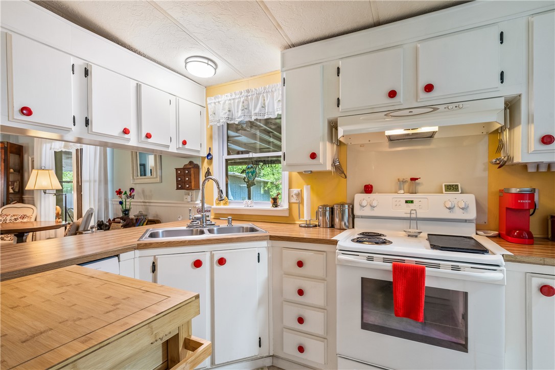 5660 Cypress Drive Yeehaw Junction, FL 34972 - Photo 4 of 36 a kitchen with kitchen island a white stove top oven sink and cabinets
