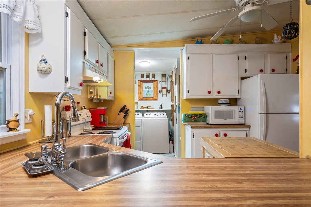 5660 Cypress Drive Yeehaw Junction, FL 34972 - Photo 9 of 36 a kitchen with stainless steel appliances granite countertop a sink refrigerator and microwave