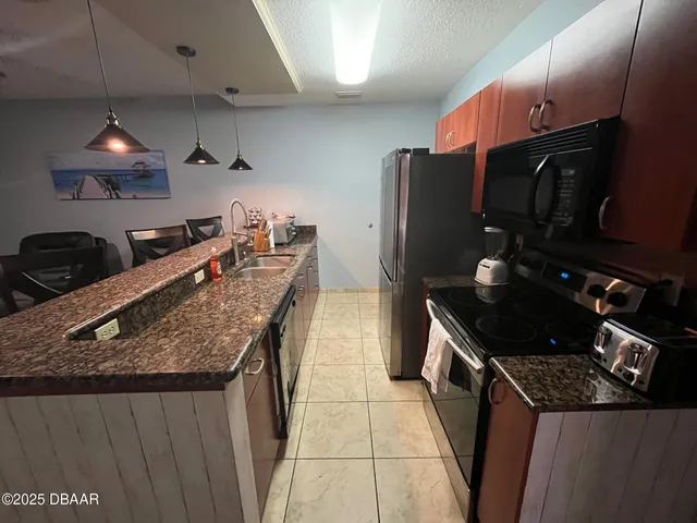 a kitchen with granite countertop a stove and a sink