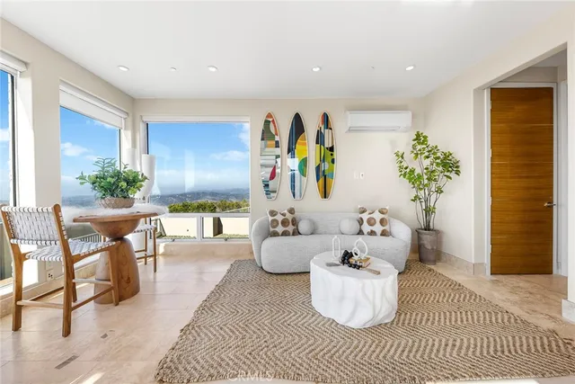 a large living room with stainless steel appliances furniture a large window and a chandelier