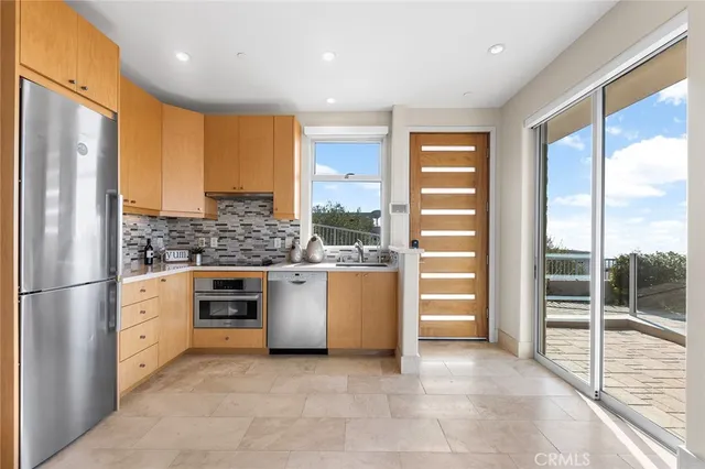 a kitchen with stainless steel appliances kitchen island granite countertop a table and chairs in it