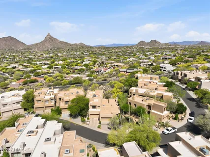 an aerial view of residential houses with outdoor space and trees