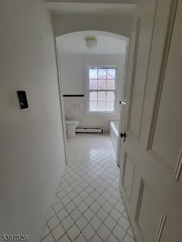 a view of empty room with wooden floor and window