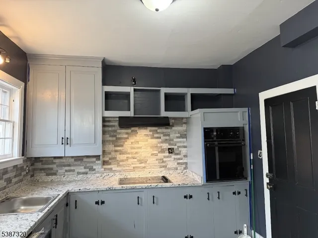a kitchen with granite countertop a stove and a refrigerator