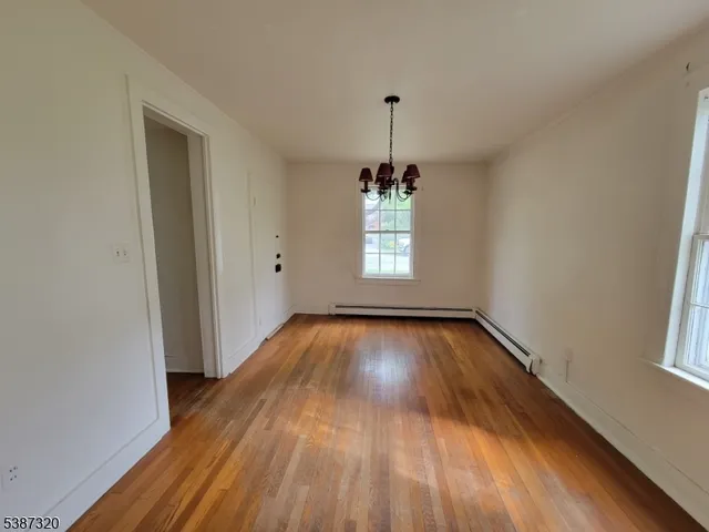 a view of empty room with window and wooden floor