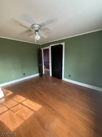 an empty room with a ceiling fan and carpet