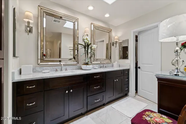 a spacious bathroom with double vanity a double vanity sink a double vanity and a mirror