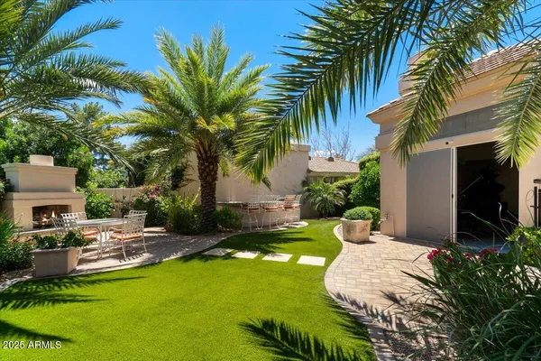 a view of a patio with table and chairs potted plants and palm trees