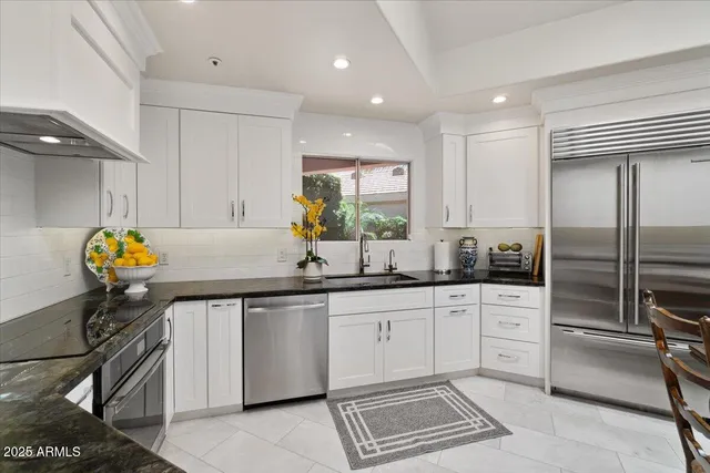 a kitchen with granite countertop a sink stainless steel appliances and cabinets