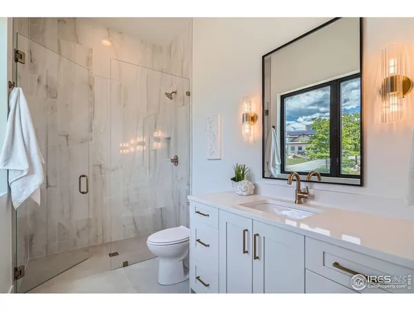 a bathroom with a granite countertop sink toilet a large mirror a bathtub and shower