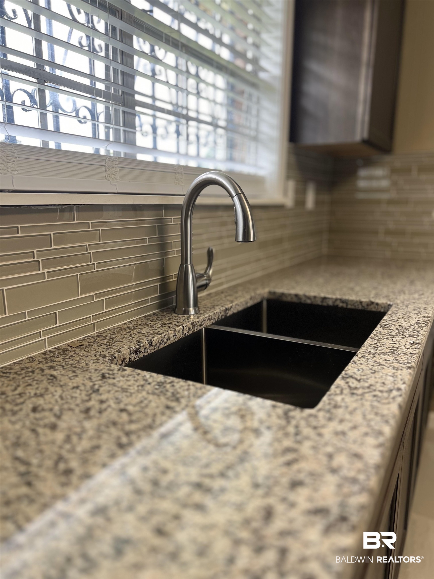 508 Freemanville Drive Atmore, AL 36502 - Photo 13 of 27 Room details featuring sink, decorative backsplash, and light stone counters