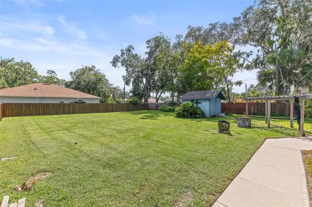 a front view of house with yard and trees in the background
