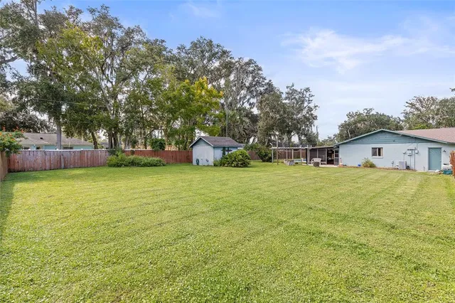 a house view with swimming pool and trees around