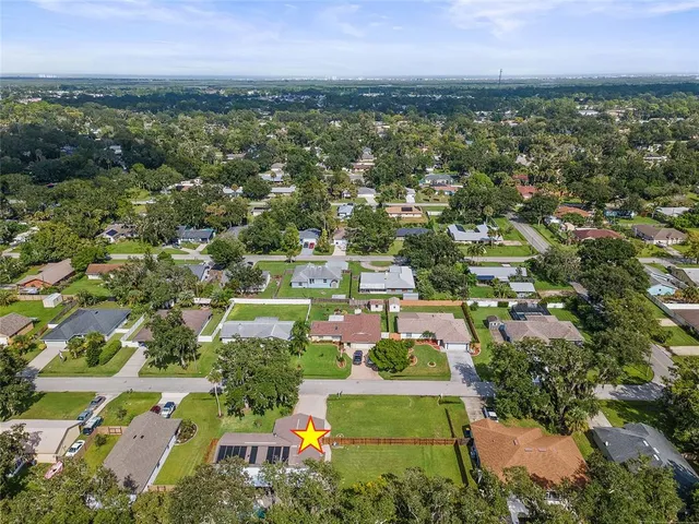 an aerial view of residential houses with outdoor space and trees